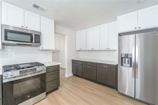 kitchen with stainless steel appliances, visible vents, and white cabinetry