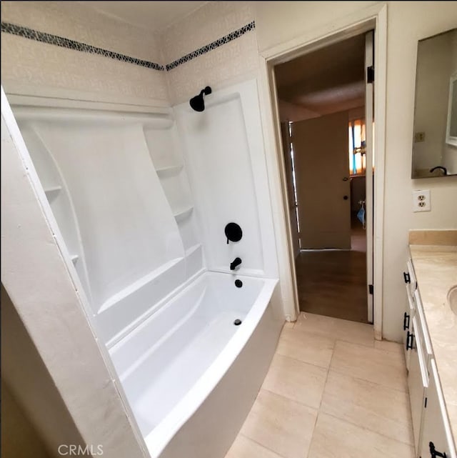 full bathroom featuring washtub / shower combination, tile patterned flooring, and vanity