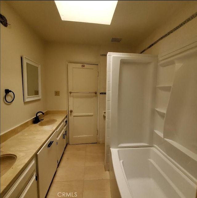bathroom with a sink, double vanity, visible vents, walk in shower, and tile patterned flooring