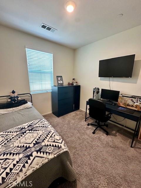 carpeted bedroom with visible vents and baseboards