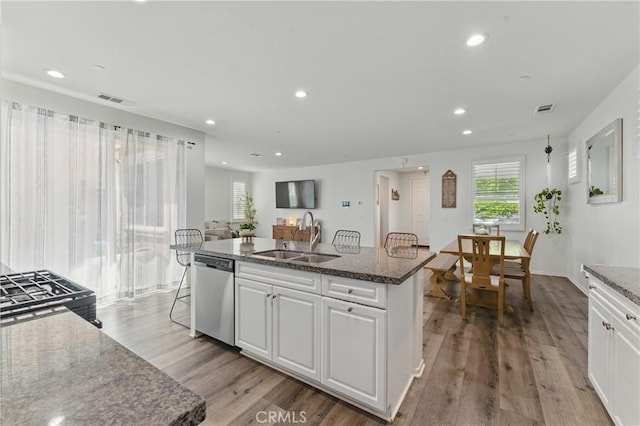 kitchen featuring a sink, light wood-type flooring, visible vents, white cabinetry, and stainless steel dishwasher
