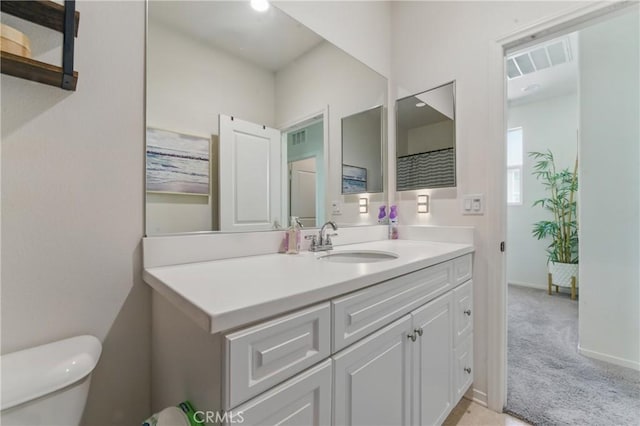 bathroom with baseboards, visible vents, toilet, and vanity