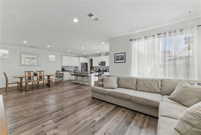 living room featuring visible vents, wood finished floors, and recessed lighting