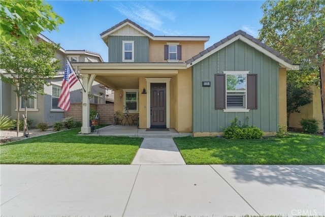view of front of home featuring a porch, a front yard, board and batten siding, and fence