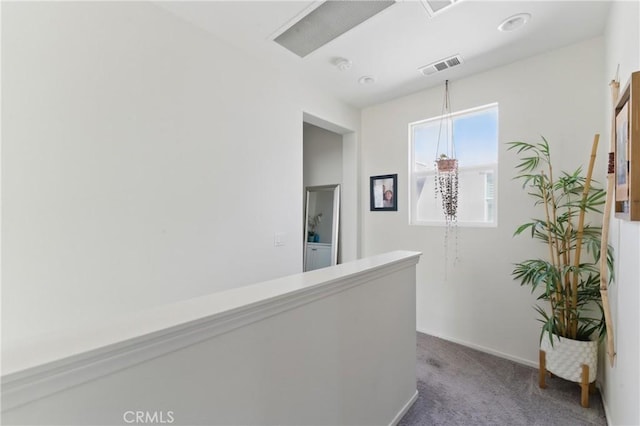 hall featuring visible vents, carpet, and baseboards