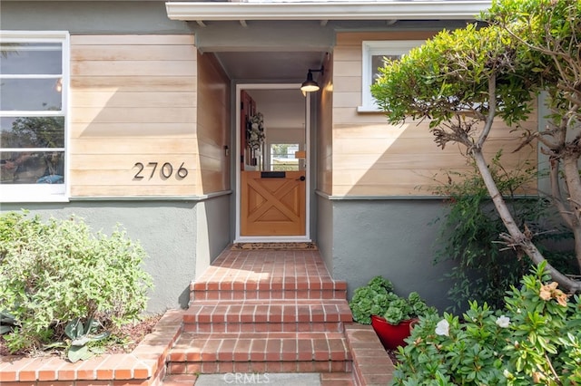 property entrance with stucco siding and a garage