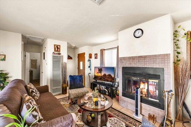 living room featuring a fireplace, visible vents, and light tile patterned flooring