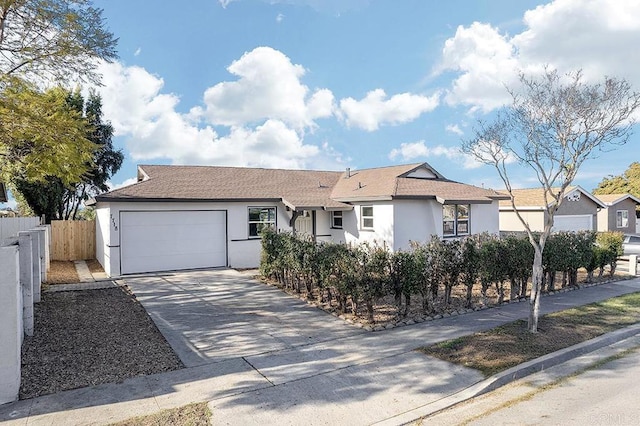 ranch-style home with driveway, a garage, fence, and stucco siding