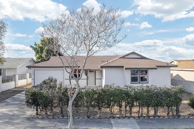 single story home with a fenced front yard, concrete driveway, an attached garage, and stucco siding