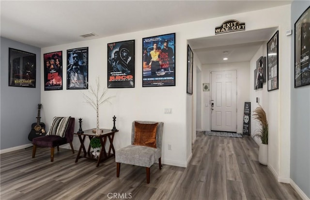 sitting room with baseboards, visible vents, and wood finished floors