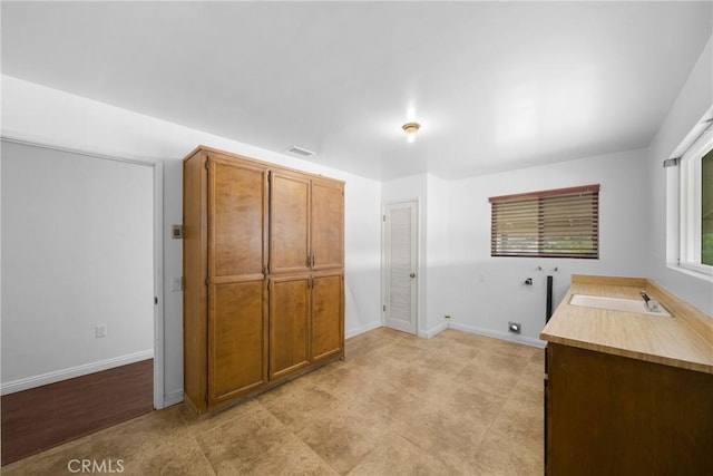 washroom featuring a sink, baseboards, washer hookup, and electric dryer hookup