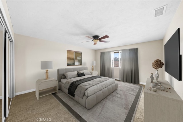 carpeted bedroom featuring baseboards, visible vents, ceiling fan, a textured ceiling, and a closet