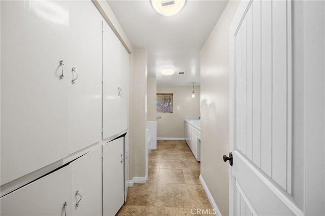 hallway with light tile patterned floors and baseboards