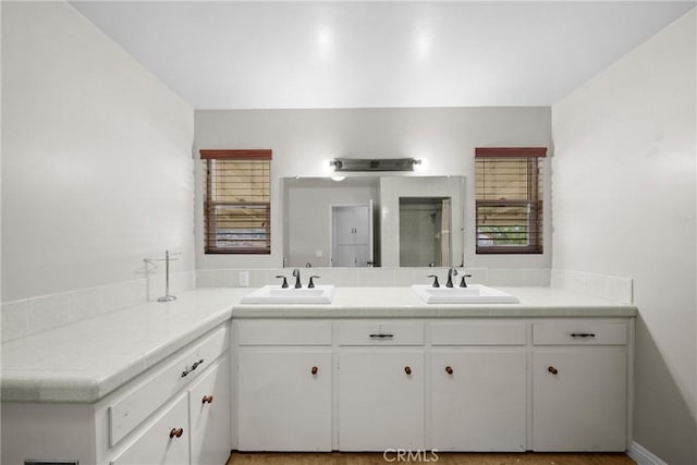 full bath with a sink and double vanity