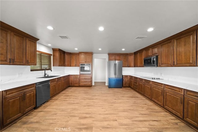 kitchen with recessed lighting, a sink, visible vents, light wood-style floors, and black appliances