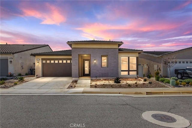 view of front facade with a garage, driveway, and stucco siding