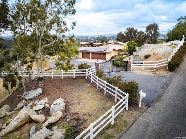 exterior space featuring a garage, a gate, fence, and driveway