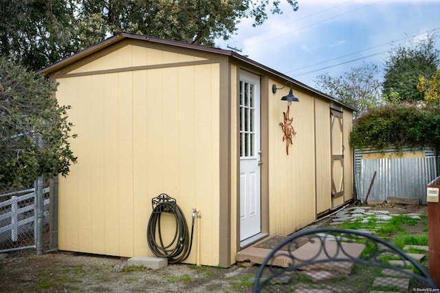 view of shed featuring fence