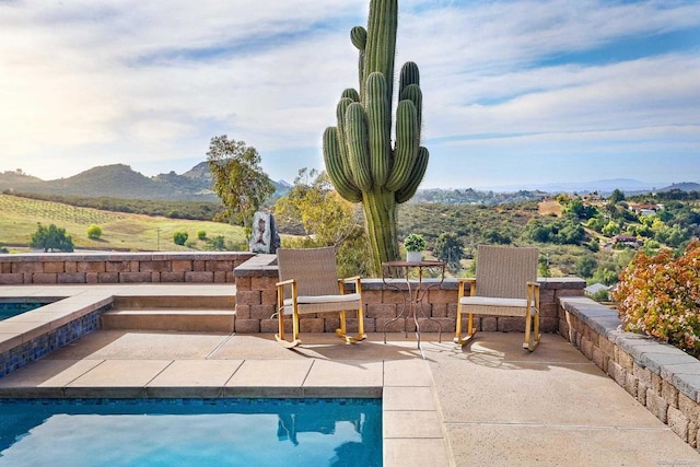 outdoor pool featuring a patio area and a mountain view