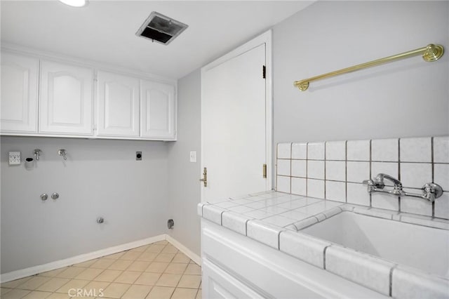 laundry room featuring a sink, baseboards, visible vents, hookup for a gas dryer, and cabinet space
