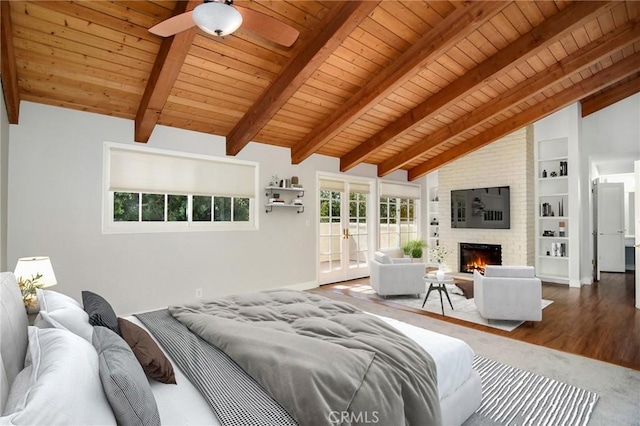 bedroom with vaulted ceiling with beams, a brick fireplace, access to outside, wood finished floors, and wood ceiling