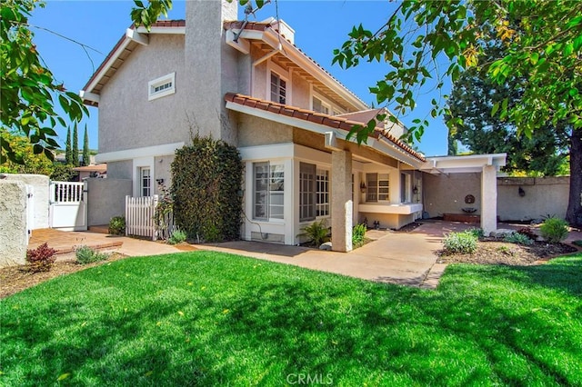 rear view of property with fence, a gate, and a yard