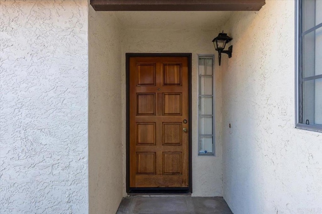 entrance to property featuring stucco siding