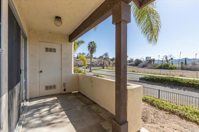 view of patio / terrace with visible vents, fence, and a balcony