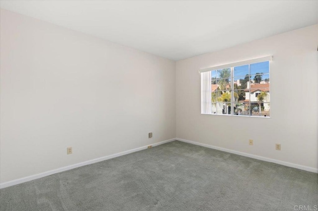 carpeted empty room featuring baseboards