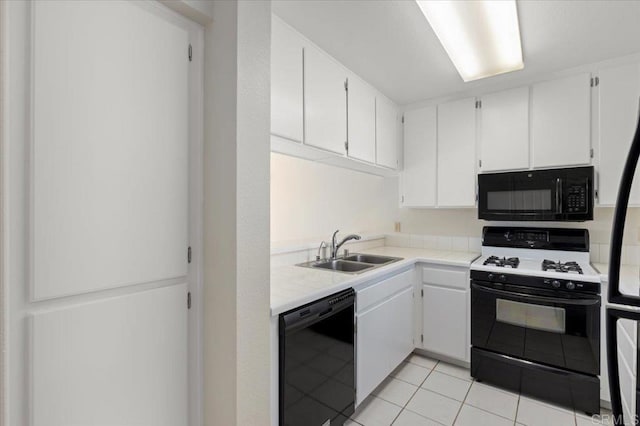 kitchen with black appliances, white cabinetry, light countertops, and a sink