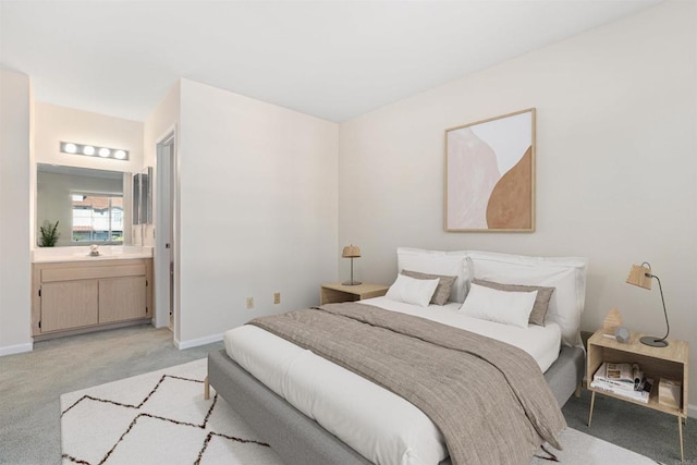 bedroom with baseboards, a sink, and light colored carpet