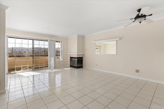 unfurnished living room featuring light tile patterned floors, baseboards, a ceiling fan, a tiled fireplace, and ornamental molding