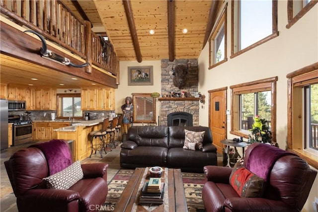 living area with wooden ceiling, high vaulted ceiling, beamed ceiling, and a stone fireplace