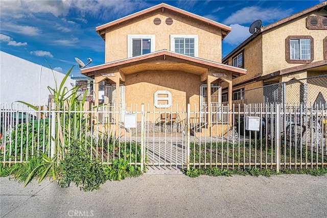 view of front facade with a fenced front yard and stucco siding