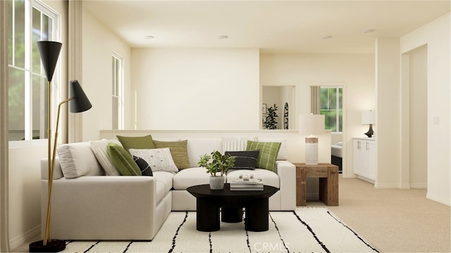 living room featuring light carpet, plenty of natural light, and baseboards