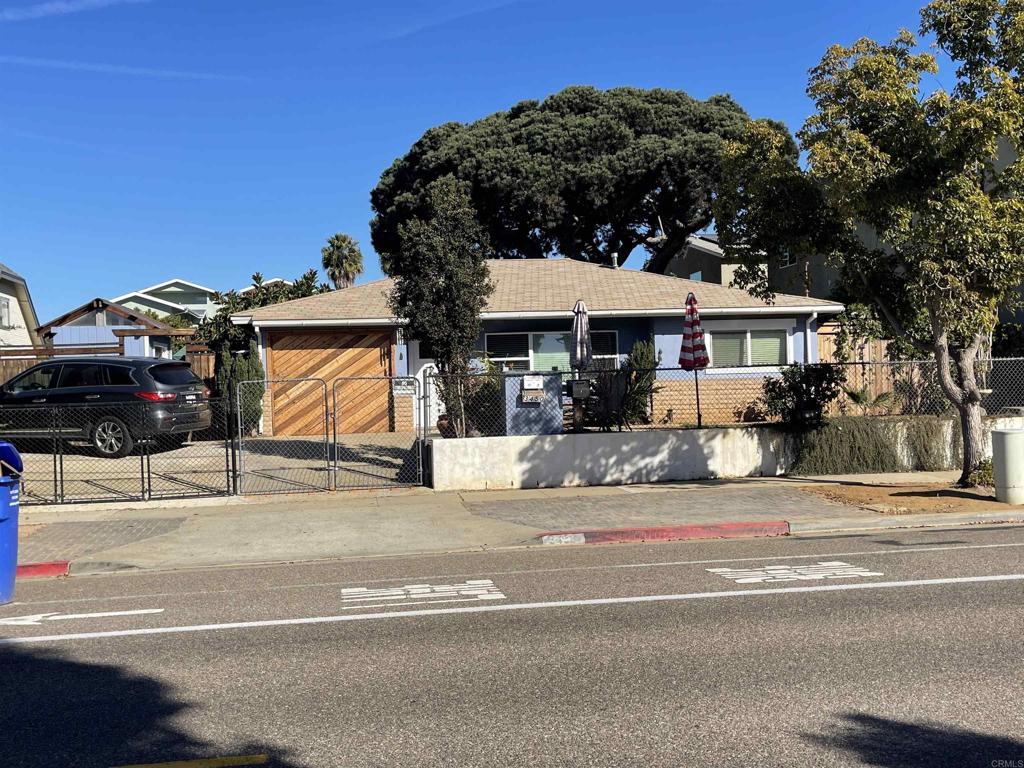 ranch-style home featuring a fenced front yard, a gate, and concrete driveway