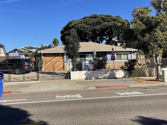 ranch-style home with a fenced front yard, a gate, and driveway