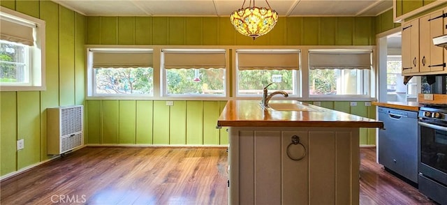 kitchen featuring dishwashing machine, heating unit, dark wood-style flooring, a sink, and a wealth of natural light