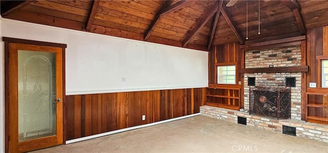 unfurnished living room with wooden walls, vaulted ceiling with beams, a fireplace, wainscoting, and wooden ceiling