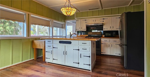 kitchen with visible vents, range, freestanding refrigerator, white cabinetry, and a sink