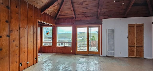 spare room with wooden ceiling, vaulted ceiling with beams, unfinished concrete flooring, and wood walls