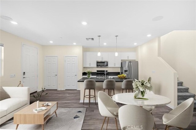 dining space with stairs, visible vents, dark wood-type flooring, and recessed lighting