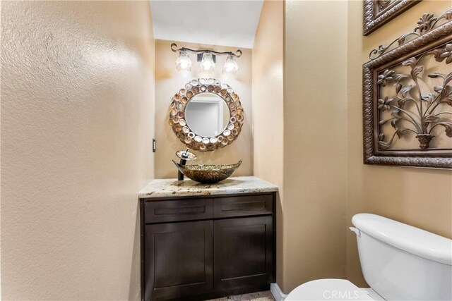 half bath featuring toilet and vanity