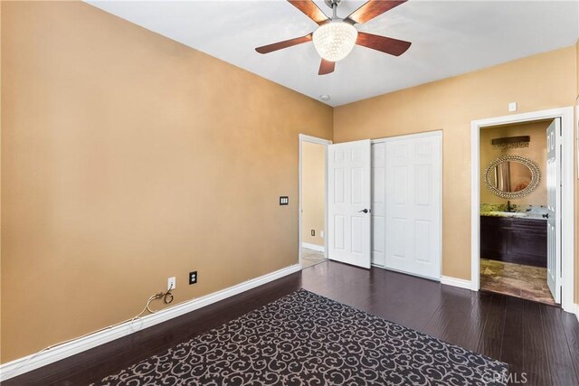 bedroom with a closet, baseboards, a ceiling fan, dark wood-style flooring, and a sink