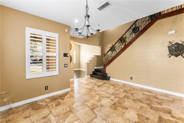 entrance foyer featuring an inviting chandelier, baseboards, stairs, and visible vents