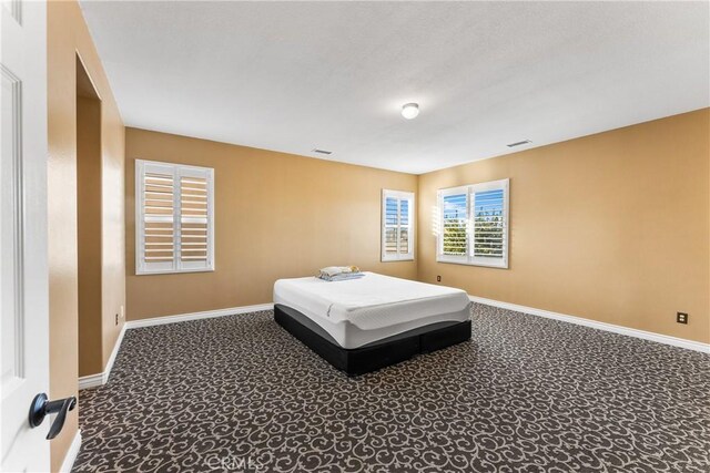 carpeted bedroom with visible vents and baseboards