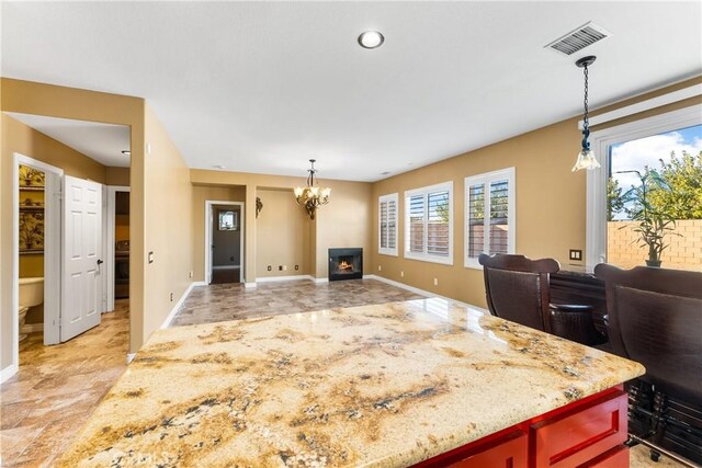 kitchen featuring open floor plan, an inviting chandelier, visible vents, and decorative light fixtures