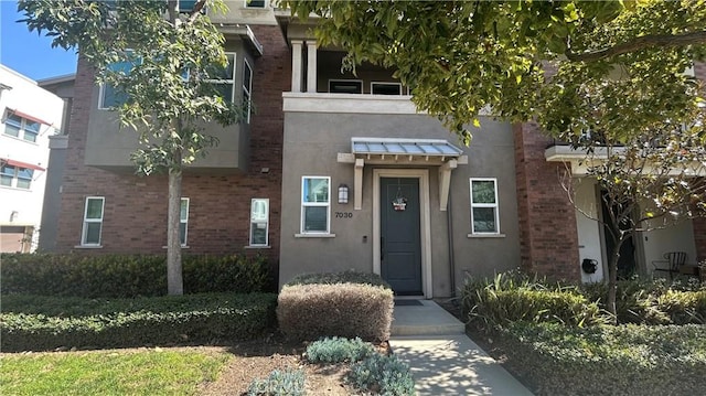 property entrance featuring brick siding and stucco siding