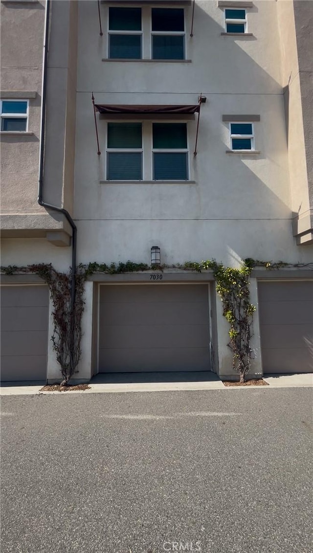 view of side of property featuring a garage and stucco siding