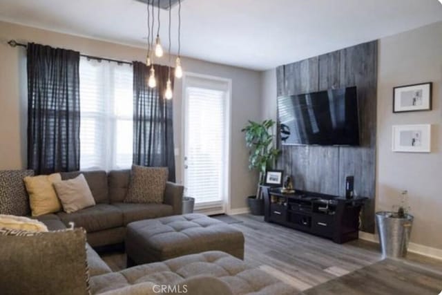 living area with baseboards and wood finished floors